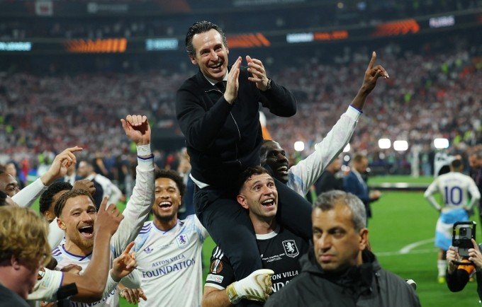 Thủ môn Emiliano Martinez công kênh HLV Unai Emery để mừng chức vô địch Europa League, , trên sân Besiktas Park, Istanbul, Thổ Nhĩ Kỳ hôm 20/5. Ảnh: Reuters