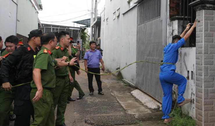 Công an đưa Nguyễn Đức Anh đến hiện trường để thực nghiệm hành vi. Ảnh: CA