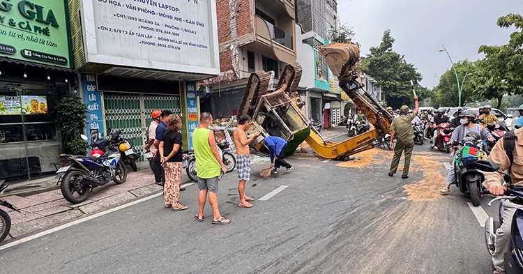 TPHCM: Xe múc đang tháo dỡ nhà bất ngờ lật ngửa giữa đường
